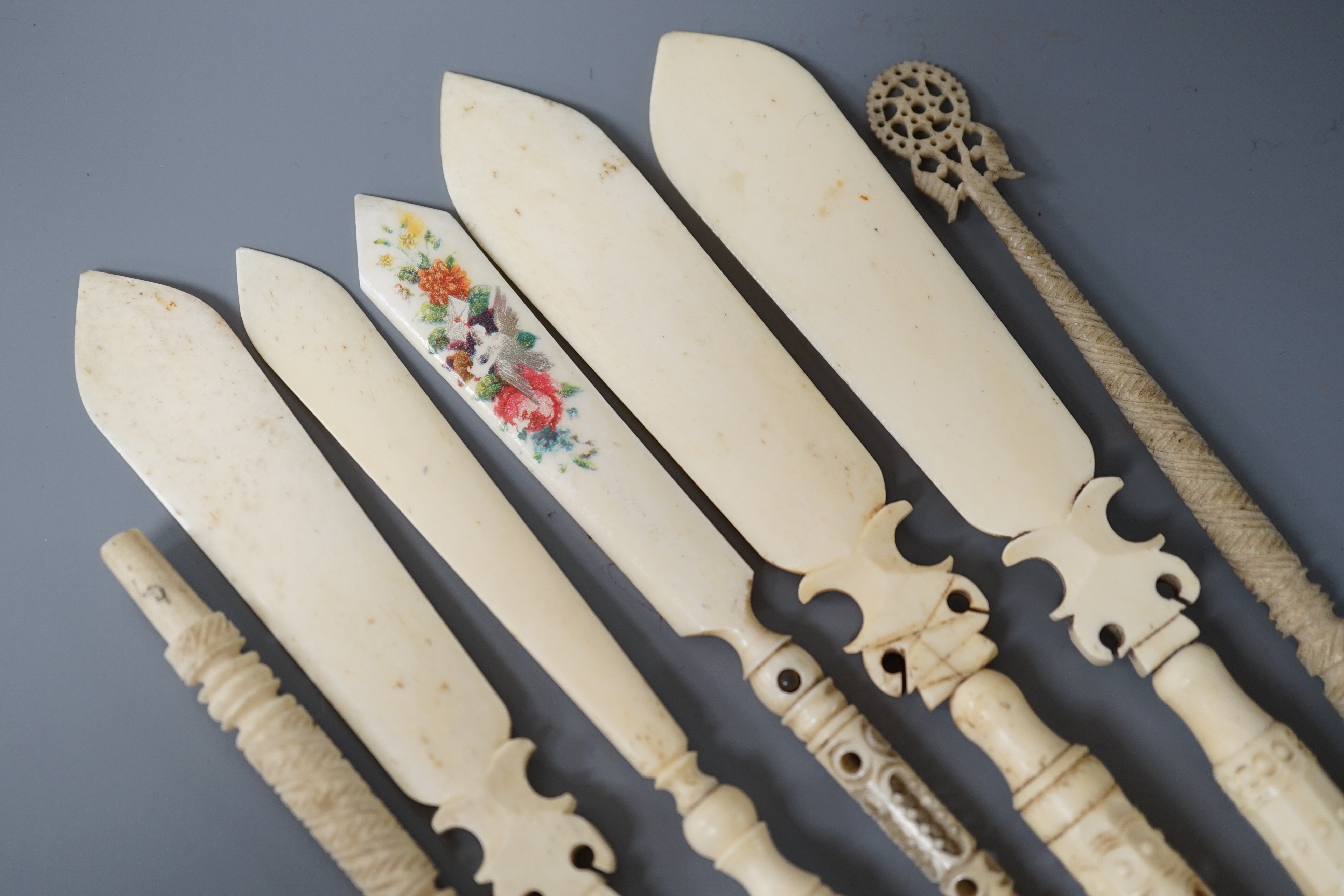 Four Victorian bone Stanhope paper knives, and three other bone items